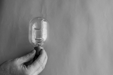 Male hand holds  vintage street spotlight incandescent bulb.
