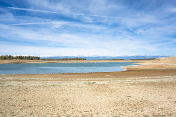 Beach and reservoir of Valdecañas, Caceres, Spain, with white foam on the shore, little water and...