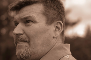 Portrait of a mature man with graying hair looking confidently into the distance.