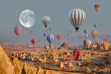 Hot air balloon flying over spectacular Cappadocia with full moon "Elements of this image furnished by NASA"