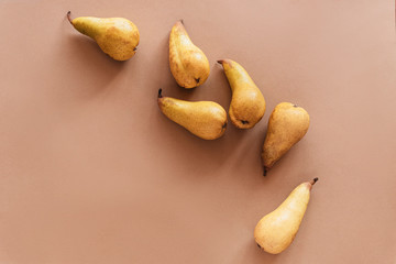 Yellow pears on brown background. Flat lay, top view, copy space