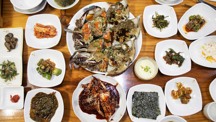 Top view image of Korean traditional cuisine on table, soy sauce marinated crab with a lot of side dishes.