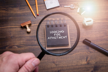 Looking for apartment. Moving, new life, studies and job search concept. Note paper, piggy bank, money and office supplies