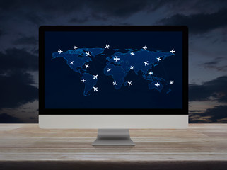 Flight routes airplanes connection and world map with desktop modern computer monitor screen on wooden table over sunset sky, Business airplane transportation network concept, Elements of this image f