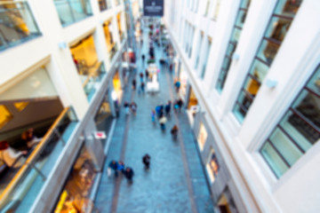 Shopping mall with customers, blurred defocused picture as background
