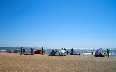 people sunbathe by the sea