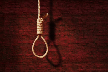 suicide concept. noose with shadow on dark wall background