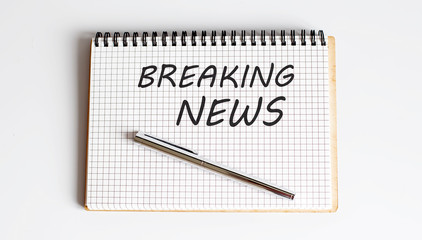 Writing note showing Breaking News. Text white notepad and pen