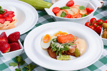 Meat with boiled eggs, lasagna, puff pastry strawberry dessert served on the table. Italian cousine concept.