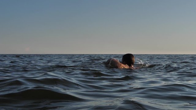 The boy drowning in the sea with his hands showing help