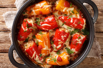 Hot baked stuffed peppers with tomato sauce close-up in a frying pan on the table. horizontal top view from above