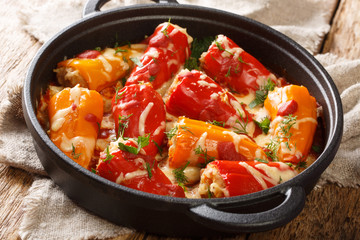 Hot baked stuffed peppers with tomato sauce close-up in a frying pan on the table. horizontal