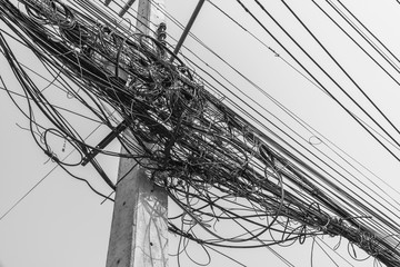 Busy high voltage cables With the cable on the electric pole on the sky background, the tangled...