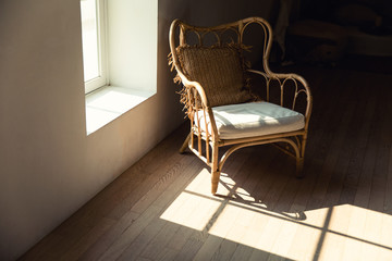 vintage chair stand near wall in sun rays and shadows