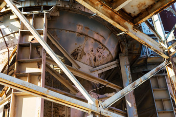 Old, abandoned concrete plant with iron rusty tanks and metal structures. The crisis, the fall of the economy, stop production capacity led to the collapse. Global catastrophe.