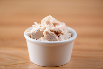 Bowl of boiled chicken on wooden background. Snack, appetizer. Copy space banner. Pizza ingredient