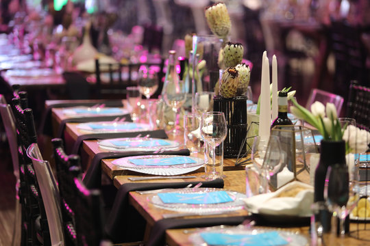 Gala Dinner Setup With White Flowers And Blue Place Cards.