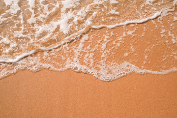 Tourist travel banner design template, copy space. White foam of a sea wave, golden sand beach, turquoise ocean water.