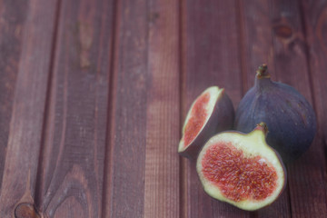 Figs laying on brown wooden table. Copy space