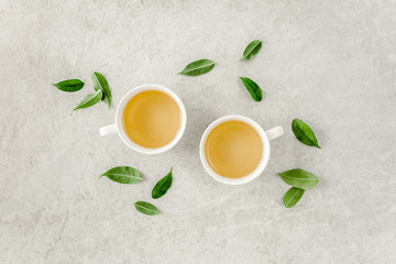 Cup of fresh green tea with tea leaves. Flat lay, top view. Tea concept