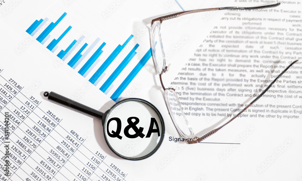 Poster q and a written on white paper on office table with charts diagrams contract and financial documents
