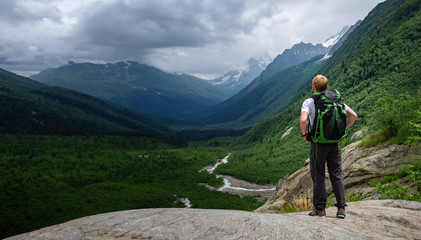 Man hiking at mountains with heavy backpack.