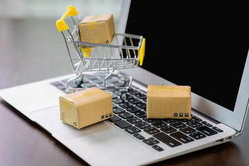 The mall cart and small paper box are empty on the laptop.Concept of buying and selling online products