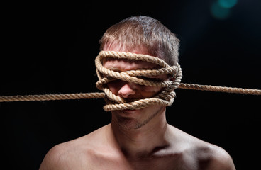Portrait of binded scary man with rope on face