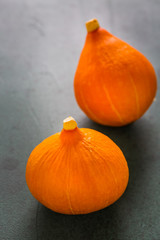 Red kuri squash on green background. Delicious edible pumpkin.