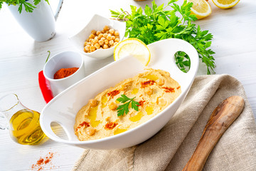 hummus paste with lemon and chilli on white background