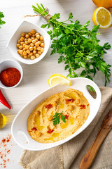hummus paste with lemon and chilli on white background