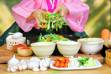 Obraz na płótnie Canvas Korean woman in national costume is making kimchi . kimchi is vegetable preservation in Korean culture for cooking.