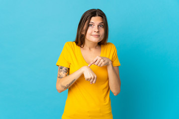 Young slovak woman isolated on blue background making the gesture of being late