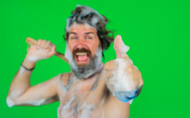 Man in bath shows thumb up. Man take a bath. Man with foam on head. Bath brush. Body washing....