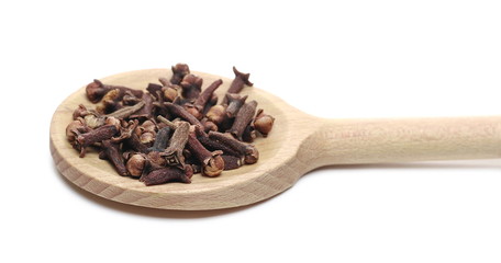 Dry cloves pile with wooden spoon isolated on white background