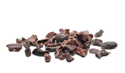 Chopped up cocoa pieces pile, isolated on white background, closeup