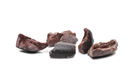 Chopped up cocoa pieces pile, isolated on white background, closeup