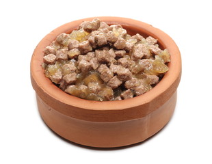 Dog food chunks, wet cubical pieces pile in clay pot, bowl isolated on white background