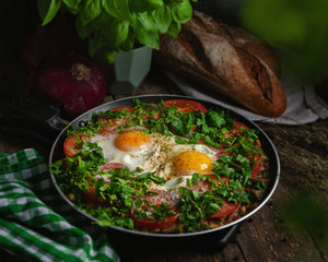 Excellent breakfast (lunch) - shakshuka. Fried eggs with vegetables in a frying pan.