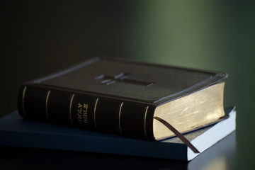 Holy bible book and wooden cross on black desk in church,prepare to study bible in christian...