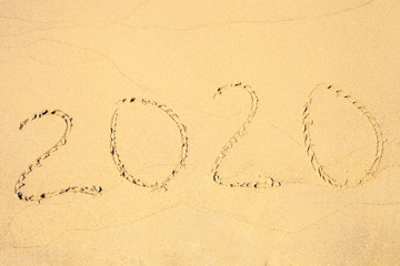 Yellow sand on summer beach with 2020 numbers, top view