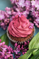Purple cupcake with purple lilac and green leaves