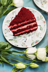 Red cake on floral plate with white flowers on blue table
