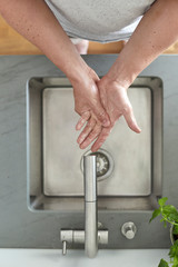 Mann wäscht sich am Waschbecken die Hände mit Seife