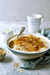 Delicious oat porridge with caramelized banana and nuts for a breakfast.