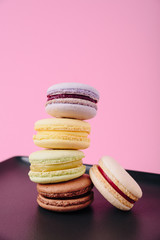 Several colorful macaroon cakes on a colored background