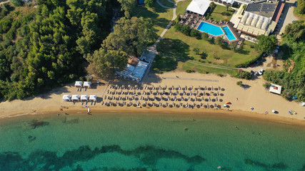 Aerial drone photo of famous organised with sun beds and umbrellas sandy beach of Agia Paraskevi in island of Skiathos, Sporades, Greece