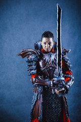Portrait of a medieval female knight in armour over blue background.