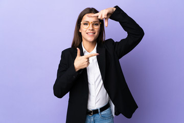 Business woman isolated on purple background focusing face. Framing symbol