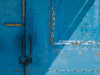 青く塗装された錆びた鉄の扉